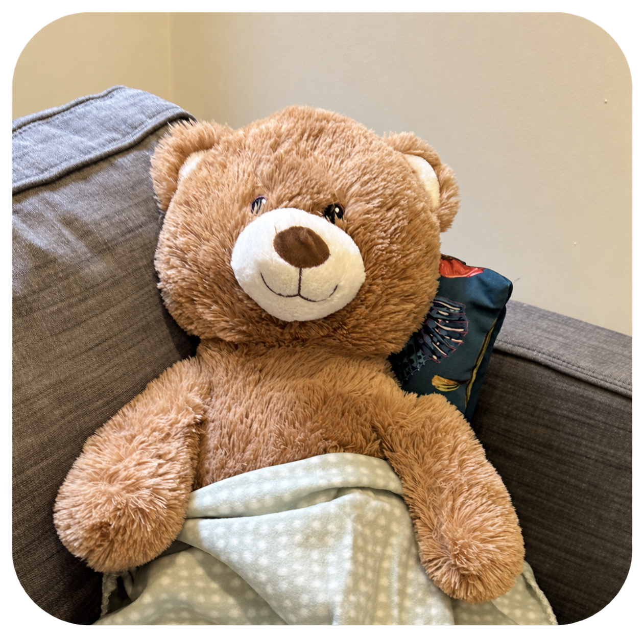 A teddy bear sitting comfortably with a soft blanket